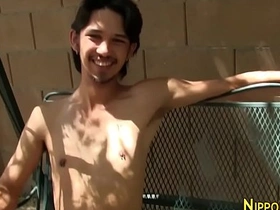 Young Asian man masturbates outdoors.