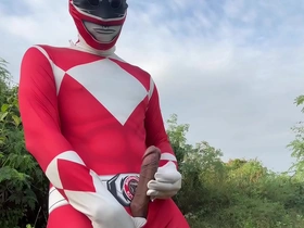 A solo masturbation scene with a Power Ranger in an outdoor setting.